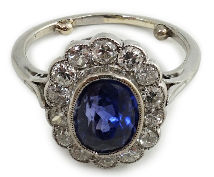 A mid 20th century white gold and millegrain set sapphire and diamond oval cluster ring